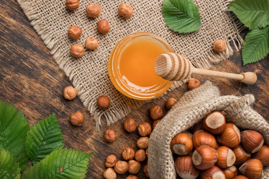 Med i lješnjaci na drvenoj podlozi – najčešća pitanja o medu